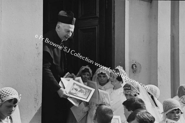 PARISH SCENE  GROUP OF CHILDREN WITH PRIEST ON DOORSTEP OF HOUSE